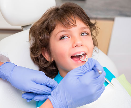 Menor sonriendo al dentista que le esta tratando